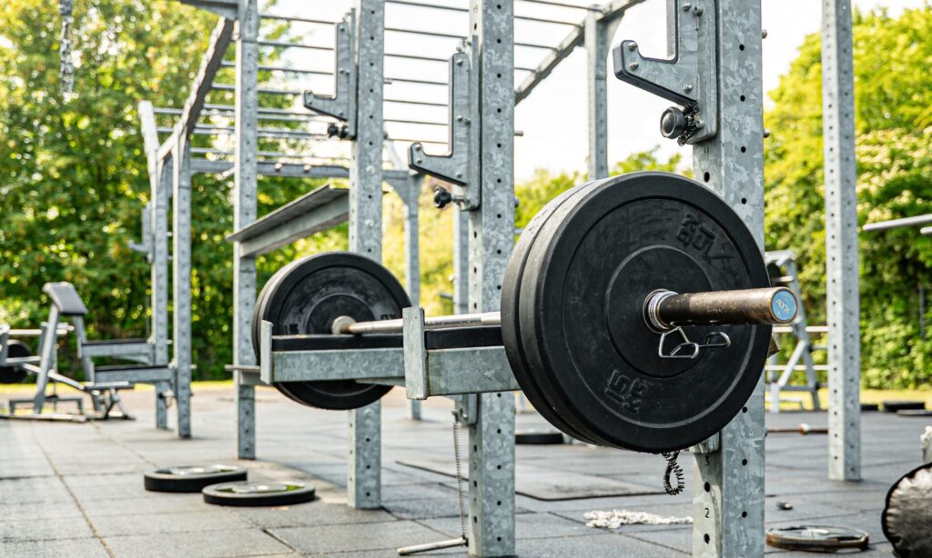 ATX Langhantel mit Gewichtsscheiben im Squat Rack des Outdoor Gym Limitless Herten